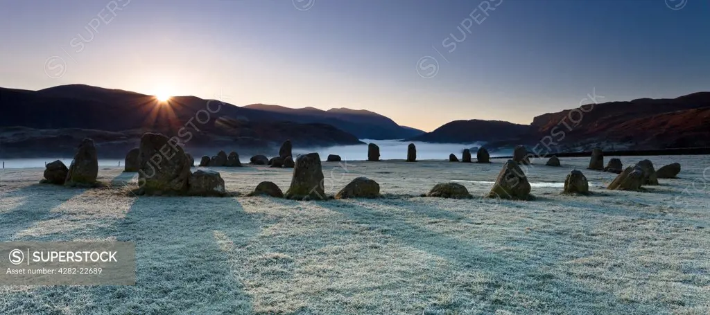England, Cumbria, near Keswick. The Castlerigg Stone Circle on a frosty morning as the first rays of light appear over the hills in the Lake District.
