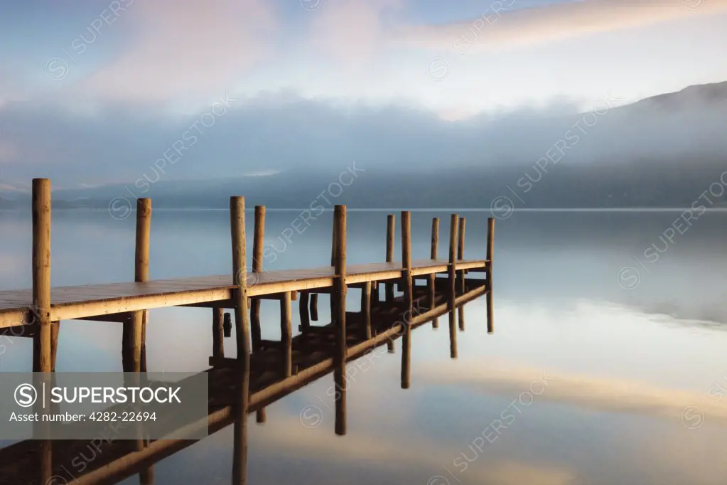 England, Cumbria, Derwentwater. The first rays of sunlight hit the landing jetty at Derwentwater in the Lake District.