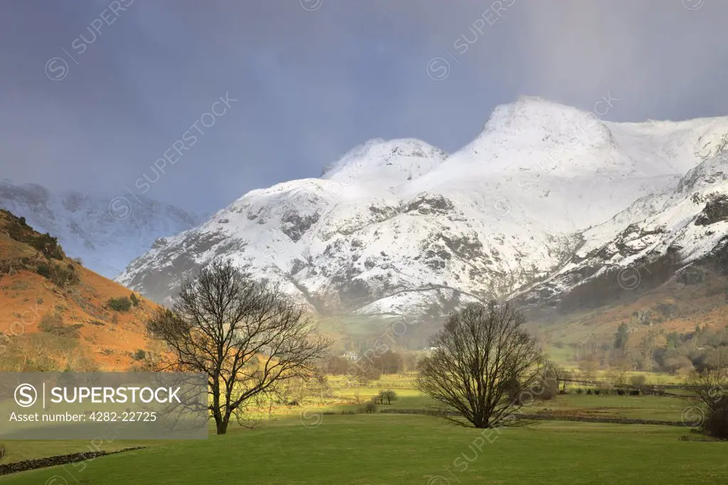 England, Cumbria, Langdale. View along the Langdale valley towards the snow capped Langdale pikes on a stormy winters day.