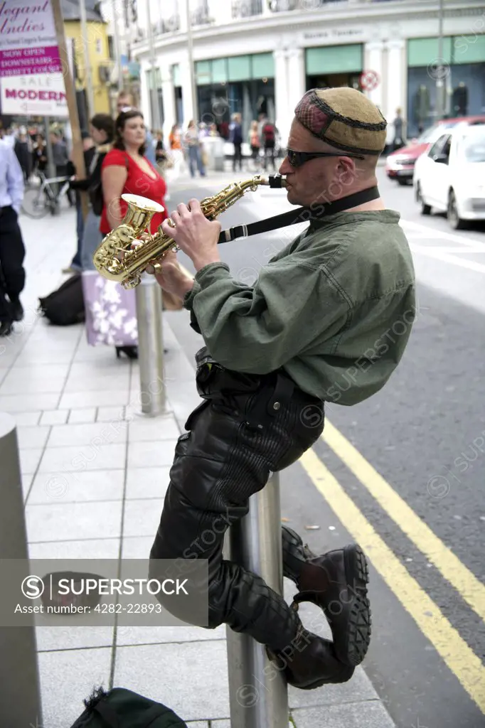 Republic of Ireland, County Galway, Galway. A busker performing with his saxaphone in Galway City.