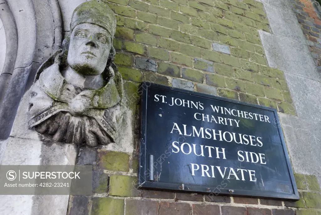 England, Hampshire, Winchester. Statue and sign at the entrance to St John's Winchester Charity Almshouses.