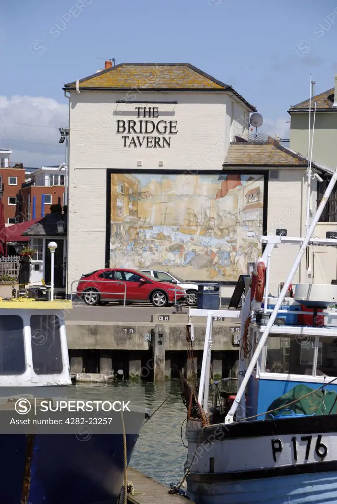 England, Hampshire, Portsmouth. A large mural of Thomas Rowlandson's ’Portsmouth Point’, which caricatured the 'spice Island’s area as a haven for drunkenness, on the wall of the Bridge Tavern in Old Portsmouth.