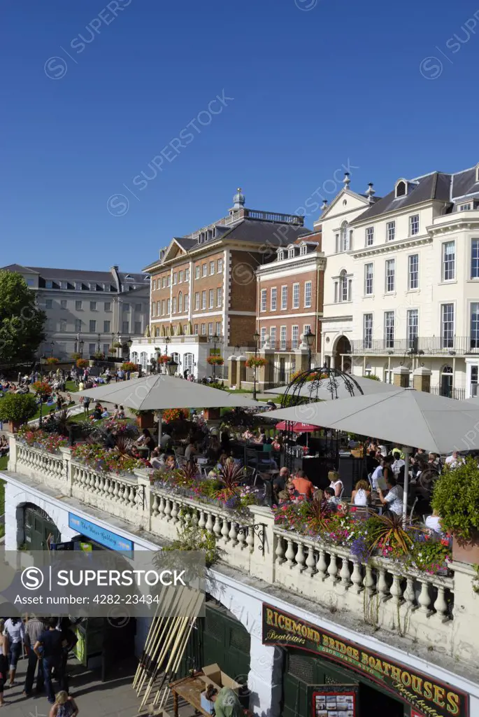 England, London, Richmond upon Thames. Summer visitors relaxing on the riverside terrace at Richmond upon Thames.
