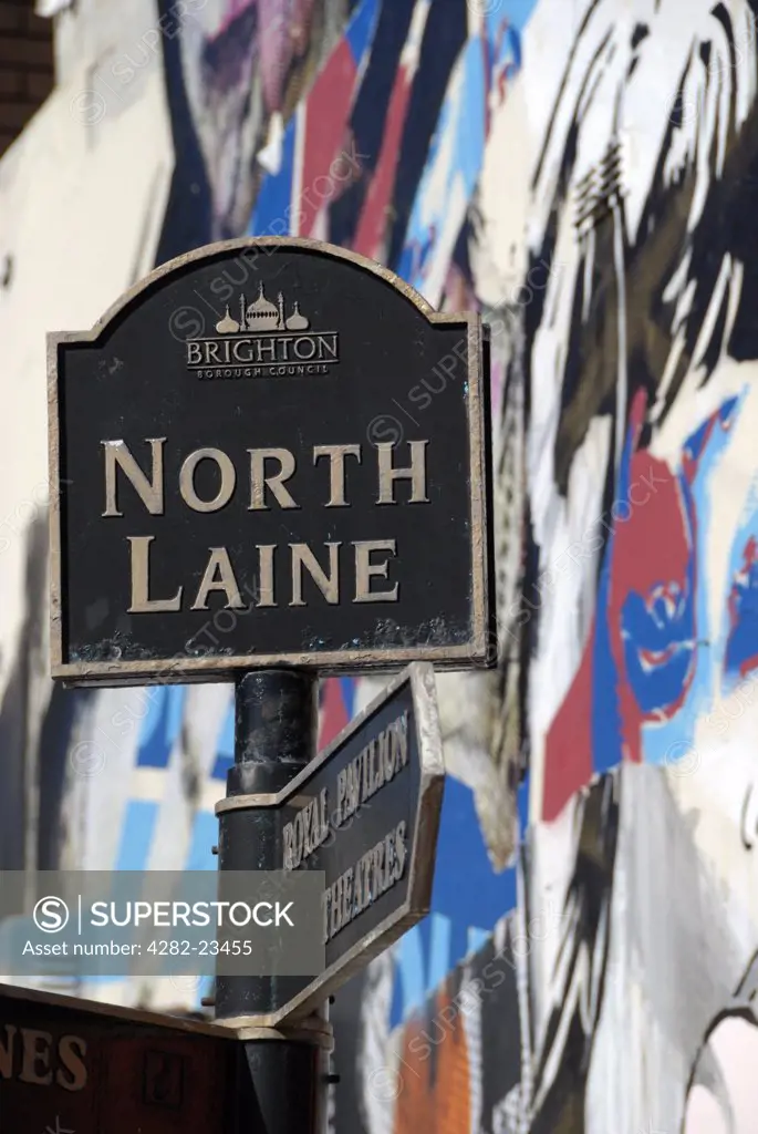 England, City of Brighton and Hove, Brighton. North Laine sign against a background mural of street art.