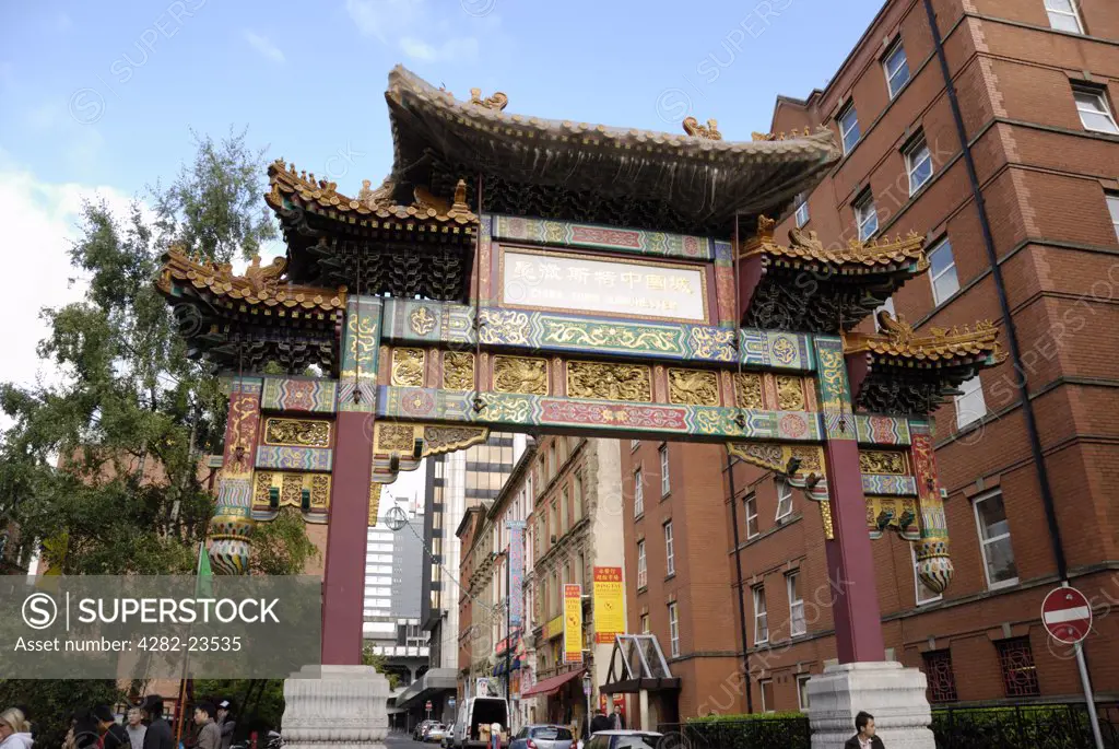 England, Greater Manchester, Manchester. The Imperial Chinese Arch in Chinatown, Manchester, painted in red and gold and adorned with dragons and phoenixes, colours and symbols of luck and prosperity.