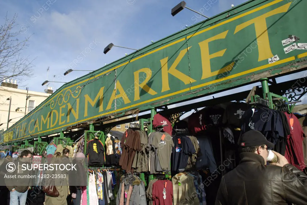 England, London, Camden Town. A view of the Camden Market sign above clothing stalls.