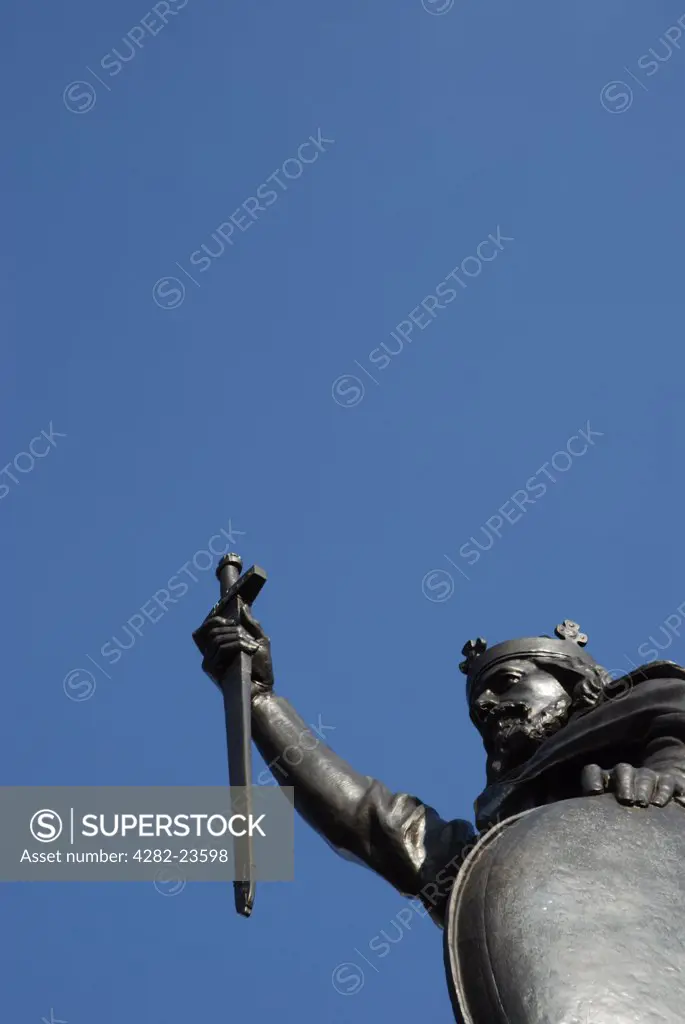England, Hampshire, Winchester. Looking up at the King Alfred statue against blue sky in Winchester.
