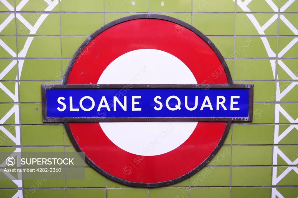 England, London, Sloane Square. Sloane Square Underground sign on a tiled wall inside the tube station.