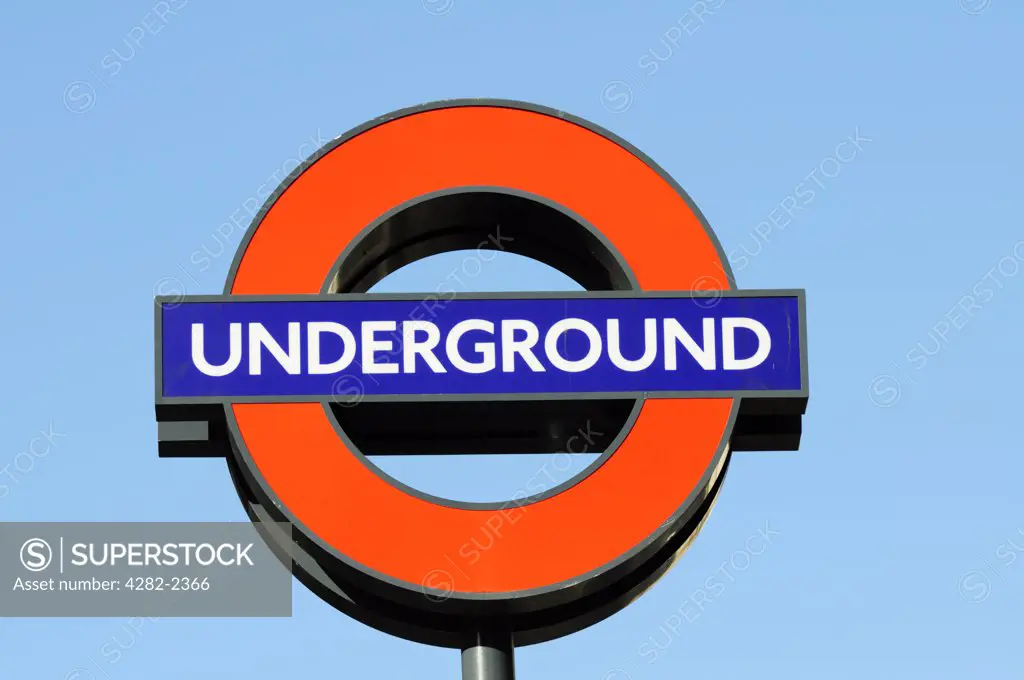 England, London. London Underground sign against a blue sky.