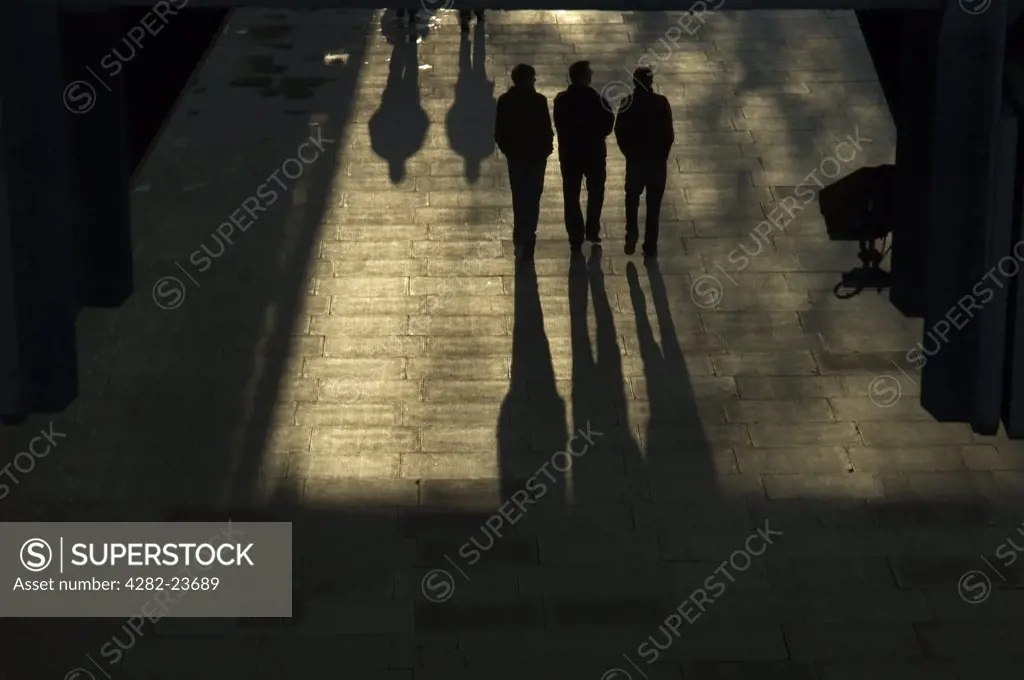 England, London, Westminster. Silhouetted pedestrians walking through an underpass in Westminster.