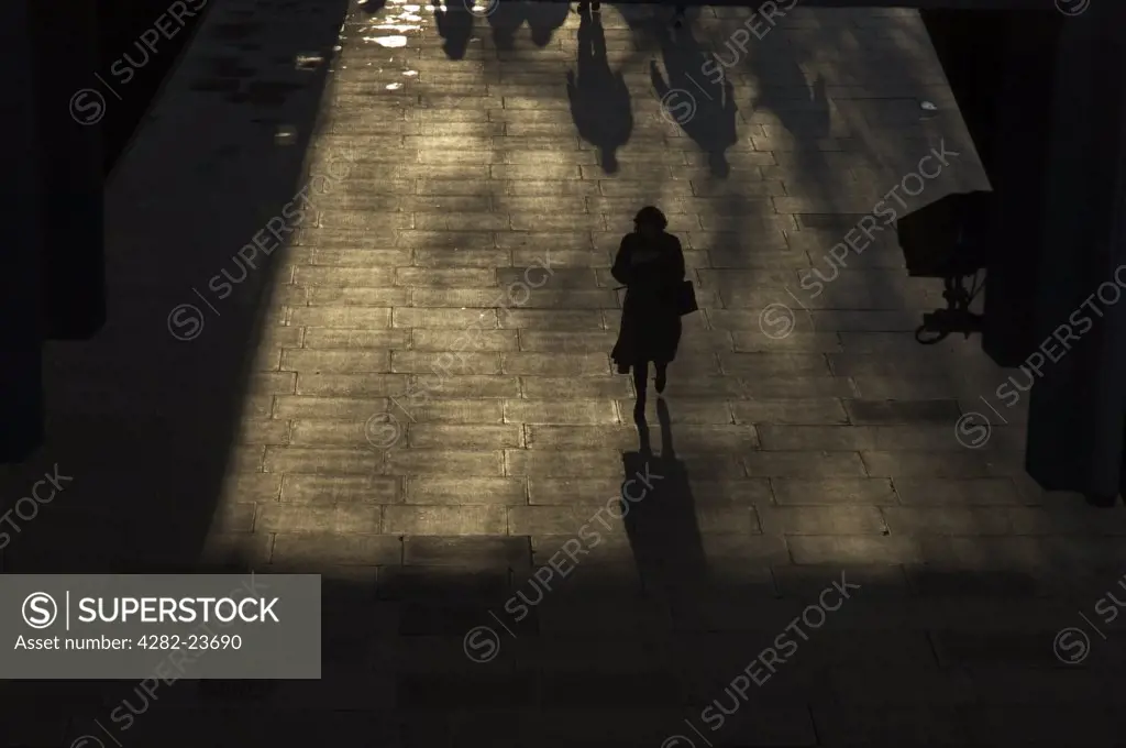 England, London, Westminster. Silhouetted pedestrians walking through an underpass in Westminster.