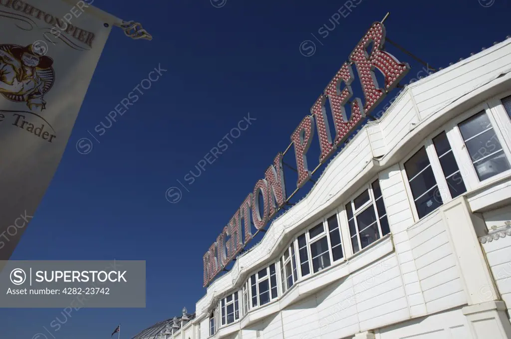 England, East Sussex, Brighton. The front of a white wooden building and large sign on Brighton Pier.