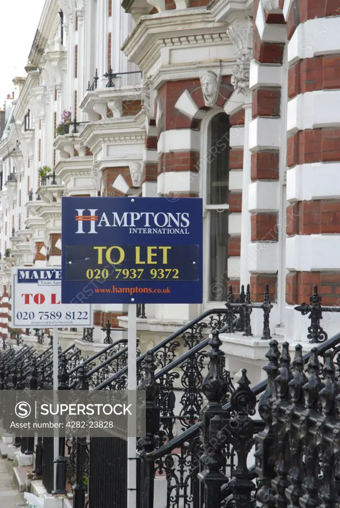 England, London, Kensington. Estate agent signs outside ornate terraced houses in Kensington.