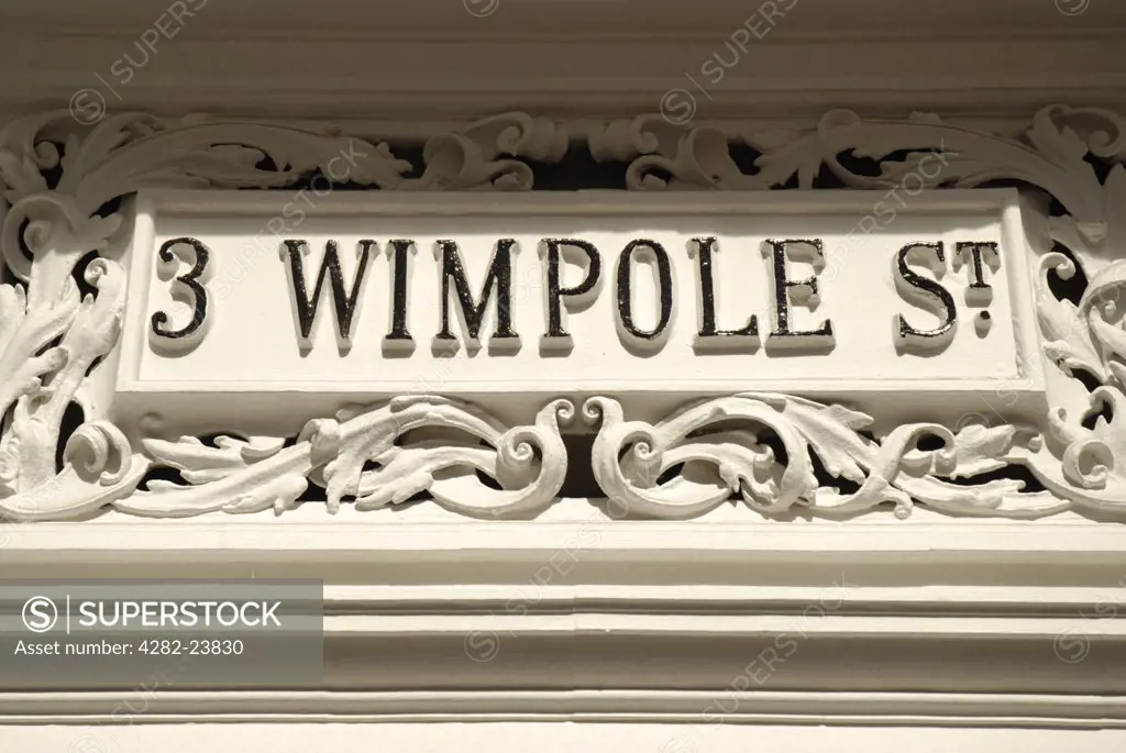 England, London, Westminster. A close up of an old ornate white stone sign on Wimpole Street.