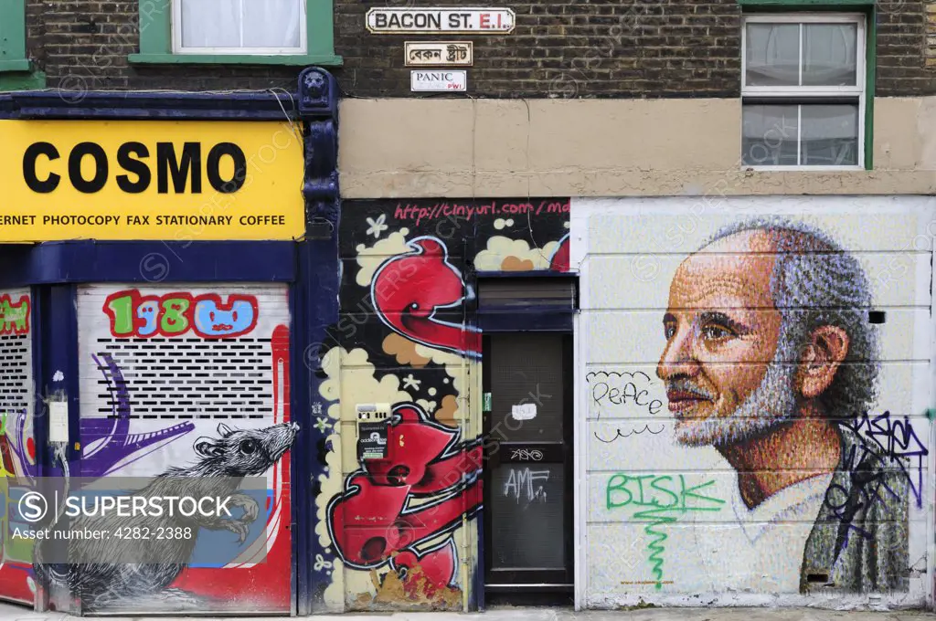 England, London, Tower Hamlets. Graffiti on buildings in Bacon Street, off Brick Lane in London's east end.