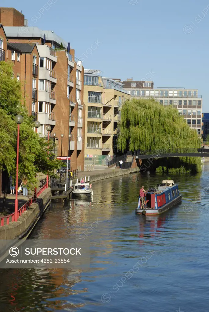 England, Berkshire, Reading. Apartment buildings overlook a barge on Kennet and Avon Canal in Reading.