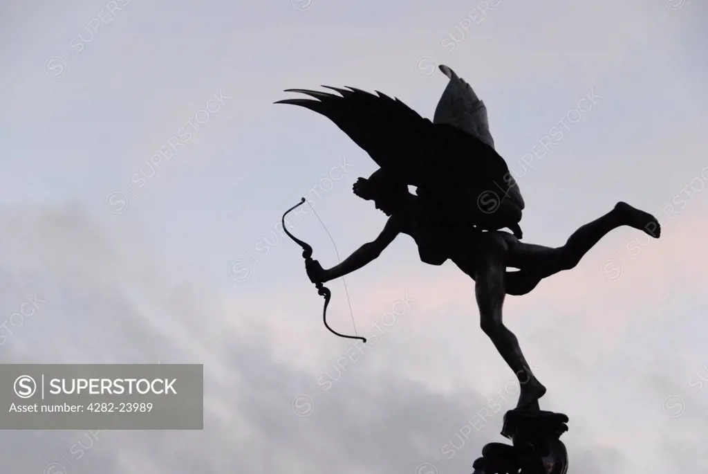 England, London, Piccadilly Circus. A silhouette of the Eros statue against pale pink and blue sky at Piccadilly Circus.