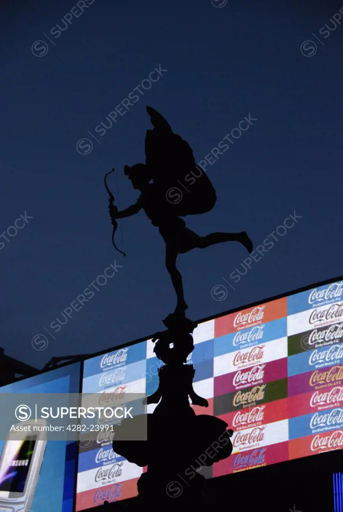 England, London, Piccadilly Circus. A silhouette of the Eros statue against  the neon advertisements of Piccadilly Circus.