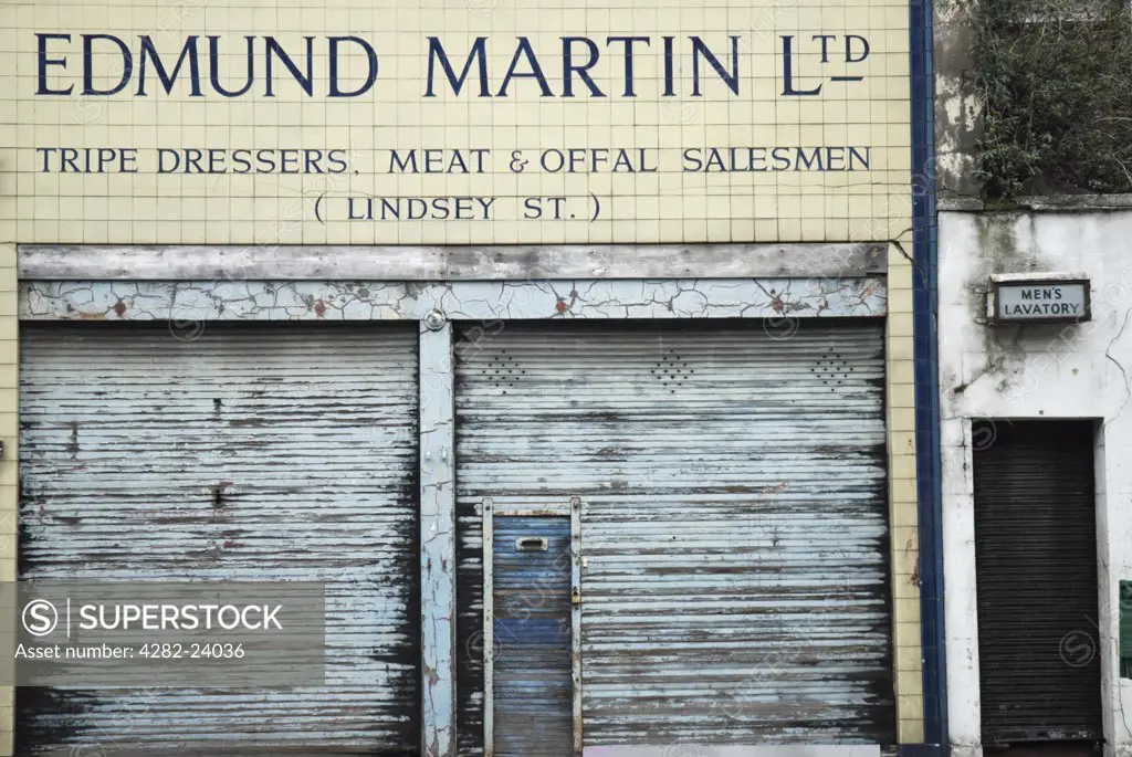 England, London, Smithfield. The front of a dilapidated shop selling tripe and offal next to the men's public toilet in Smithfield Meat Market.