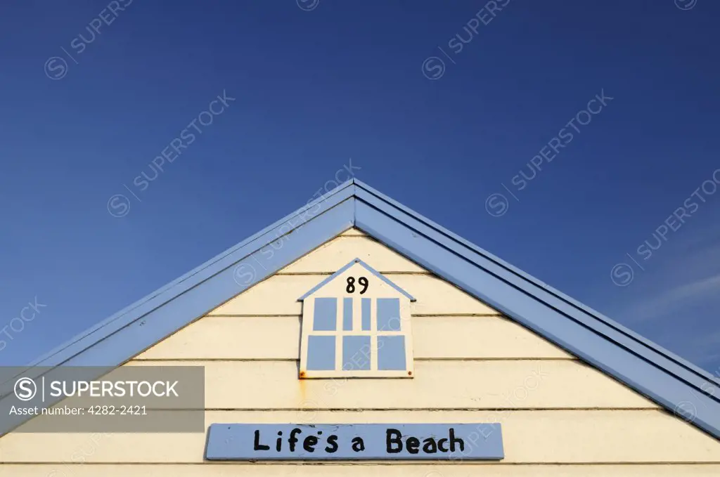 England, Suffolk, Southwold. 'Life's a Beach' displayed at the top of a beach hut.