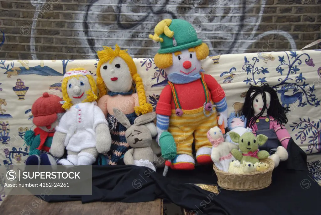 England, London, Brick Lane. A collection of colourful knitted dolls on a market stall in Brick Lane.