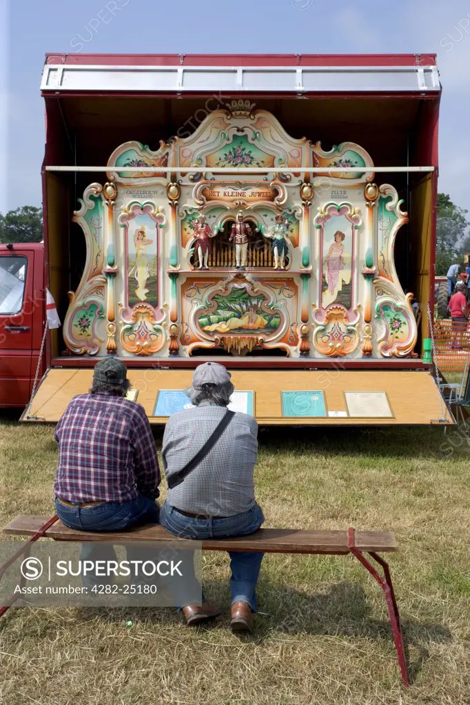 England, Hertfordshire, Whitwell. Two men looking at a steam organ at the Whitwell Steam and Country Fair.