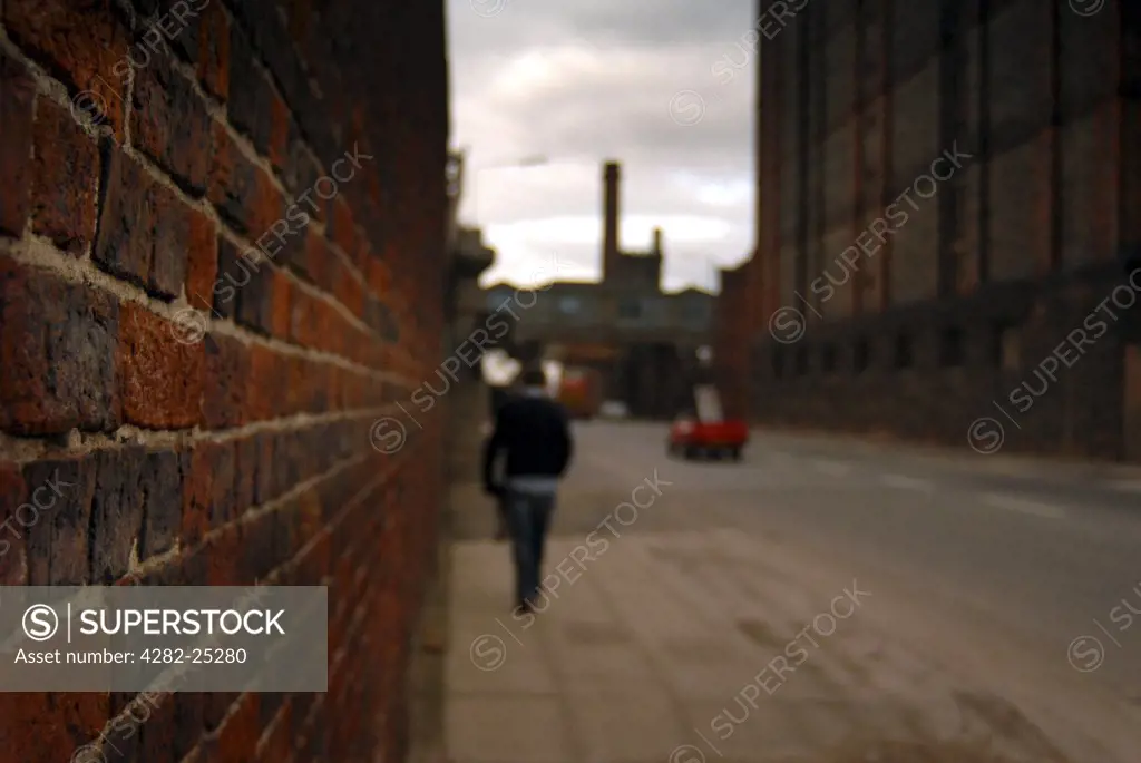 England, Merseyside, Liverpool. Man walking in Liverpool Docks. The vital role of the Docks and it's connections throughout the world made the City the biggest target outside London during World War II.