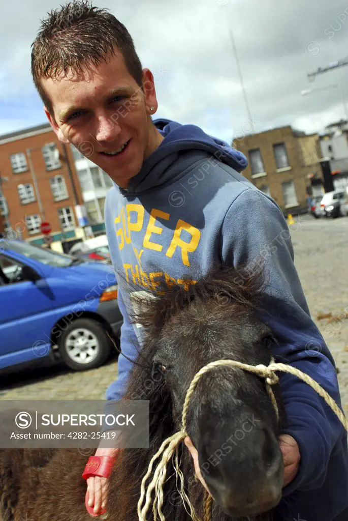 Republic of Ireland, Dublin, Smithfield Horse Market. A seller with his horse at Smithfield Horse Market in Dublin.