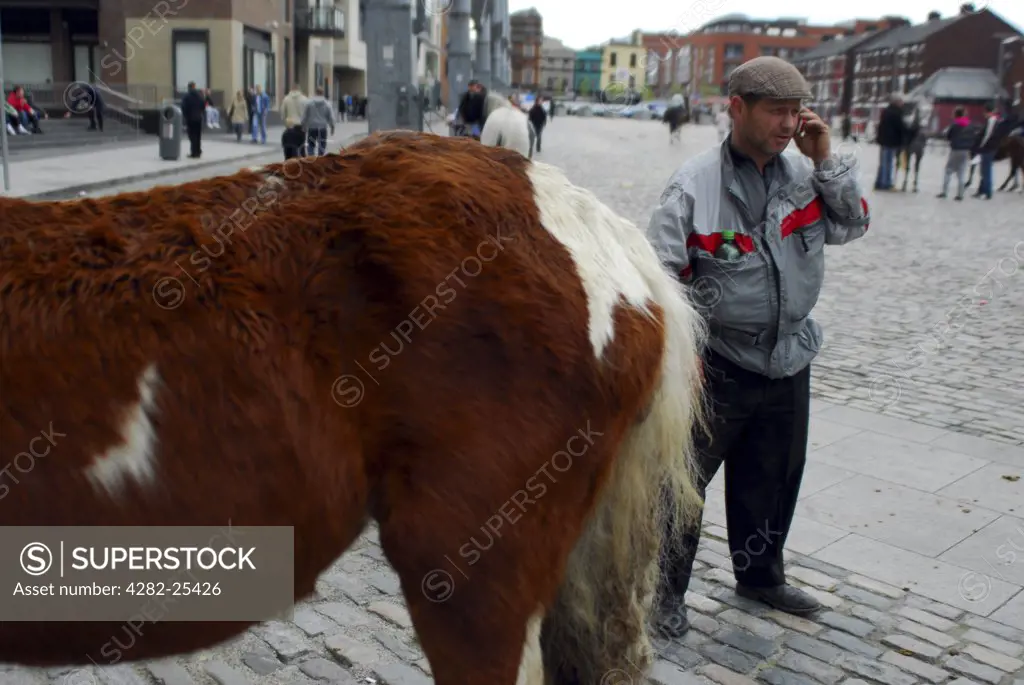 Republic of Ireland, Dublin, Smithfield Horse Market. A buyer on his mobile phone at Smithfield Horse Market in Dublin.