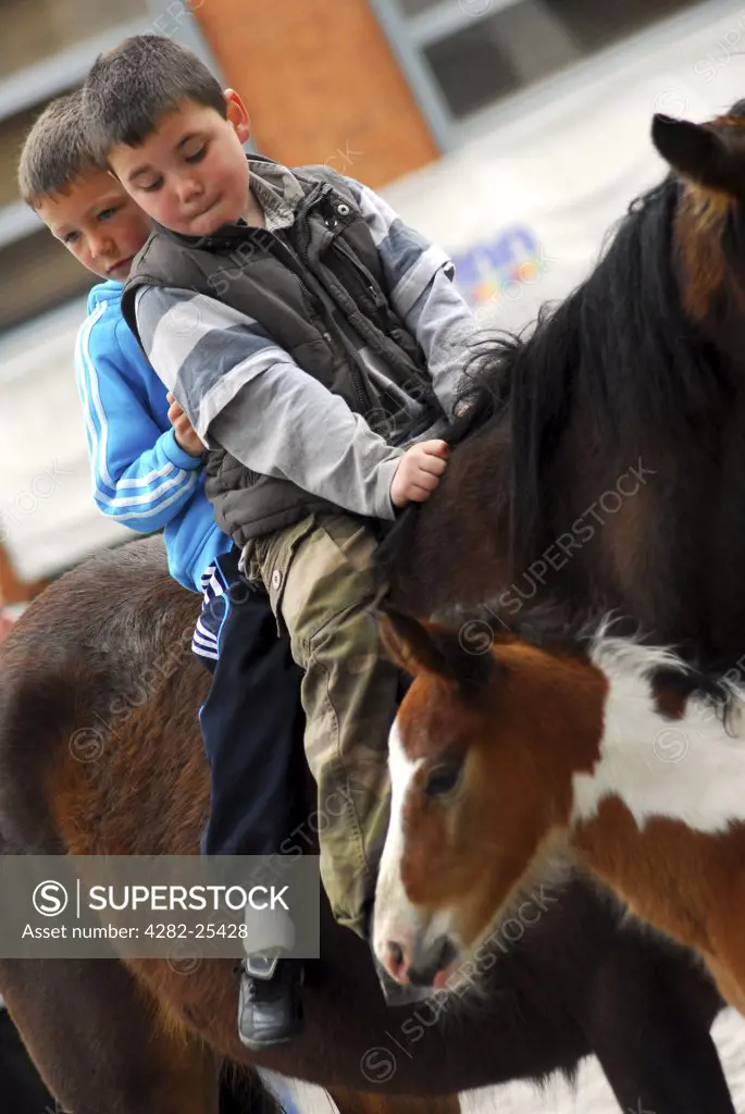 Republic of Ireland, Dublin, Smithfield Horse Market. Youngsters on horseback at Smithfield Horse Market in Dublin.
