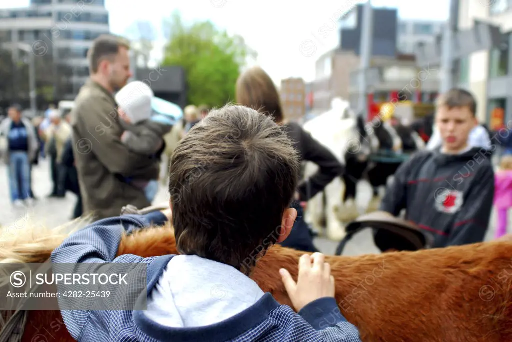 Republic of Ireland, Dublin, Smithfield Horse Market. Youngsters with the horses at Smithfield Horse Market in Dublin.
