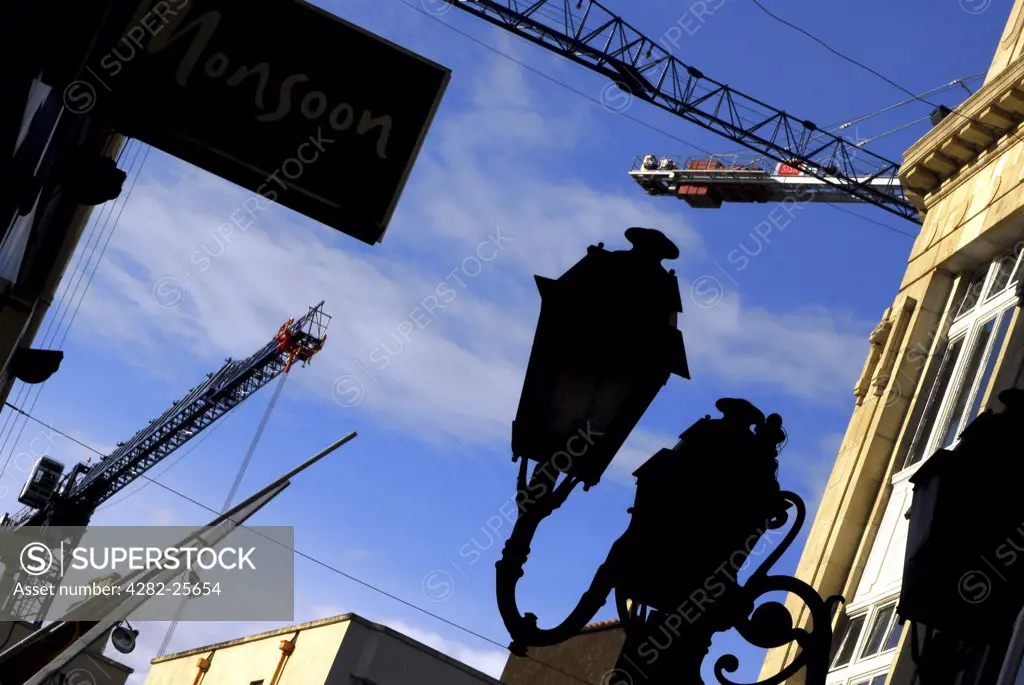 Republic of Ireland, County Cork, Central Cork. Cranes above a street scene in central Cork.