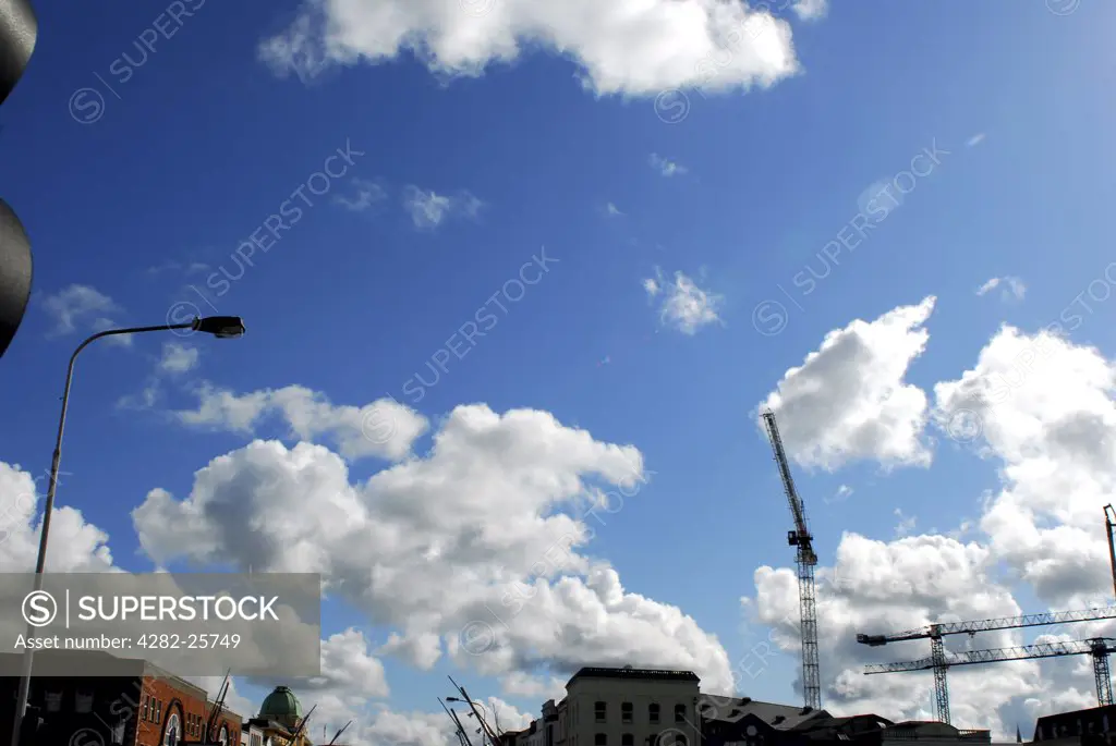 Republic of Ireland, County Cork, Central Cork. Clouds over rooftops and cranes in central Cork.