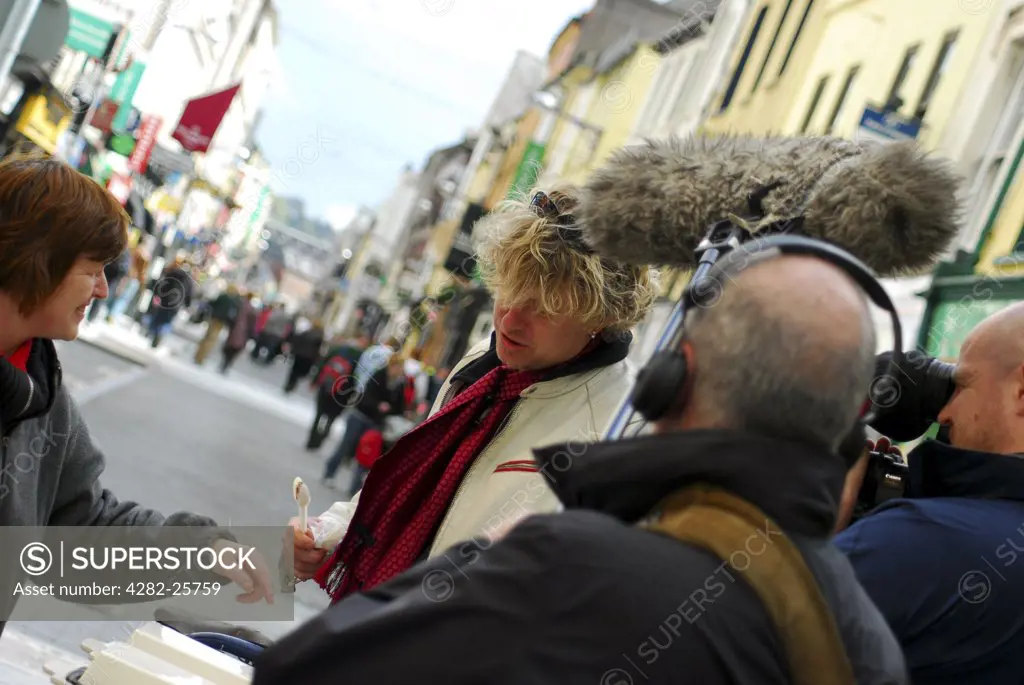 Republic of Ireland, County Cork, Central Cork. A woman interviewed in the street by a television crew in Cork.