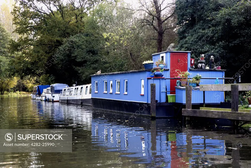 England, Surrey, Pyrford. A houseboat, narrow boat and cabin cruisers moored at Pyrford Lock on the Wey Navigation Canal.