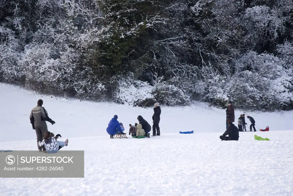 England, Surrey, Epsom. Family fun in the snow on Epsom Downs.