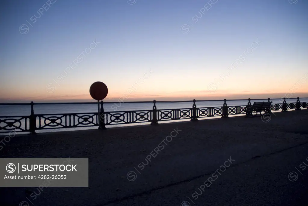 England, City of Brighton and Hove, Hove. A bench by the balustrade on the pier at Hove at sunset.