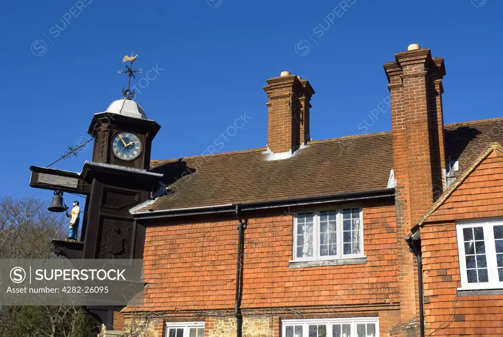 England, Surrey, Abinger Hammer. Clock in the village of Abinger Hammer showing the figure of Jack the Blacksmith who strikes the hour with his hammer.