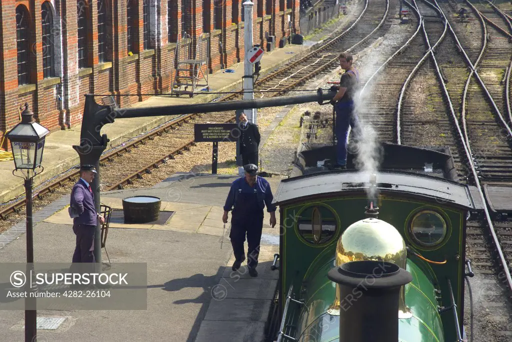 England, East Sussex, Sheffield Park. A steam locomotive taking on water at Sheffield Park Station on the Bluebell Railway.