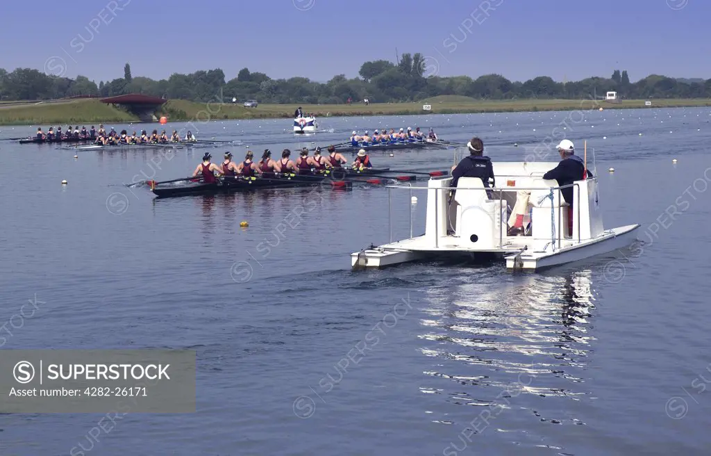 England, Buckinghamshire, Dorney. Crews of eight pass a referees boat in a a race at Eton Dorney, the venue for Rowing, Paralympic Rowing and Canoe Sprint events during the London 2012 Games.