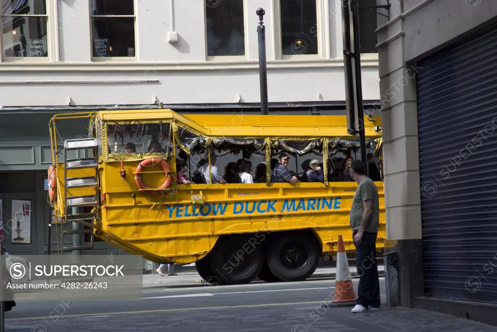 England, Merseyside, Liverpool. Tourists enjoying a sightseeing tour of Liverpool in the Yellow Duck Marine, a World War ll landing vehicle that travels along the streets and in the water at Salthouse Dock.