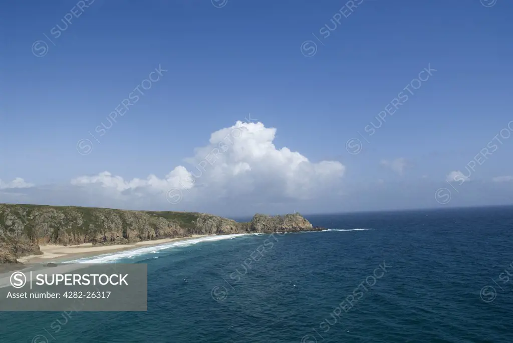 England, Cornwall, Porthcurno. Logan Rock, a balancing rock at the end of the headland that forms Porthcurno Bay.