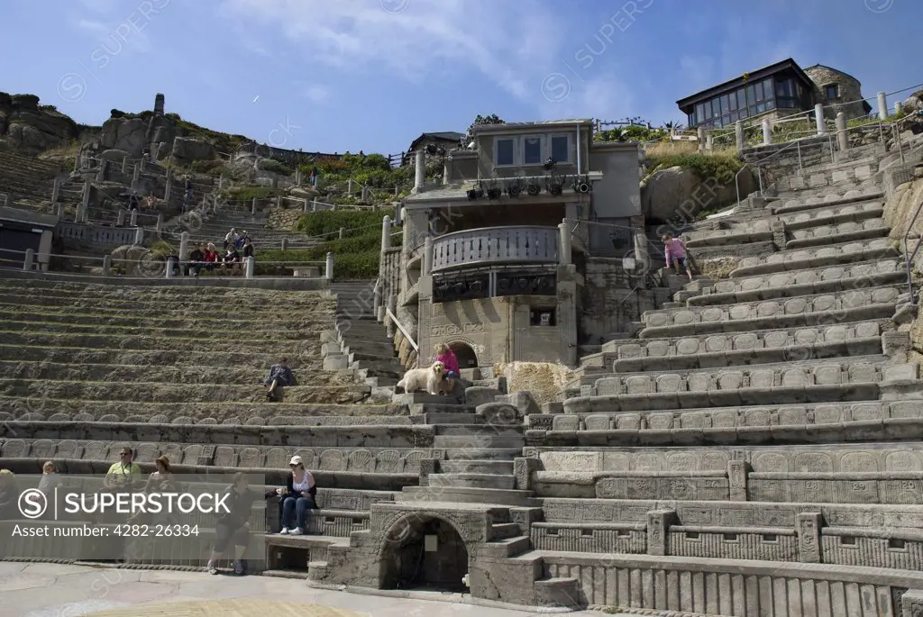 England, Cornwall, Porthcurno. Members of the audience begin to take their seats ahead of a play at the Minack Theatre, an open-air theatre carved into the granite cliff overlooking Porthcurno Bay.