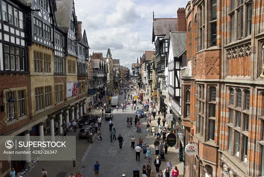 England, Cheshire, Chester. A view along Eastgate Street in Chester bustling with shoppers.