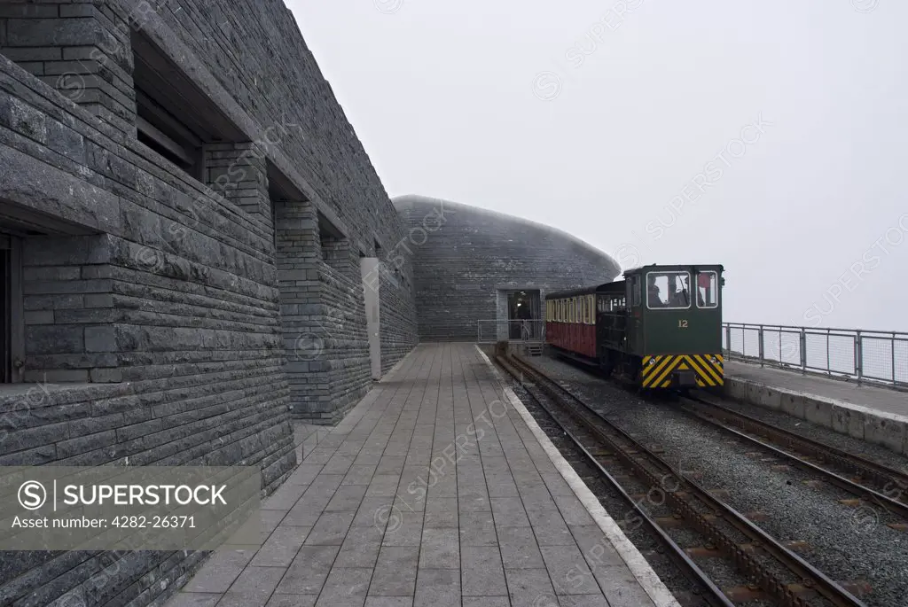 Wales, Gwynedd, Snowdon. A train on the Snowdon Mountain Railway alongside the platform outside the new Snowdon visitors centre at the summit.