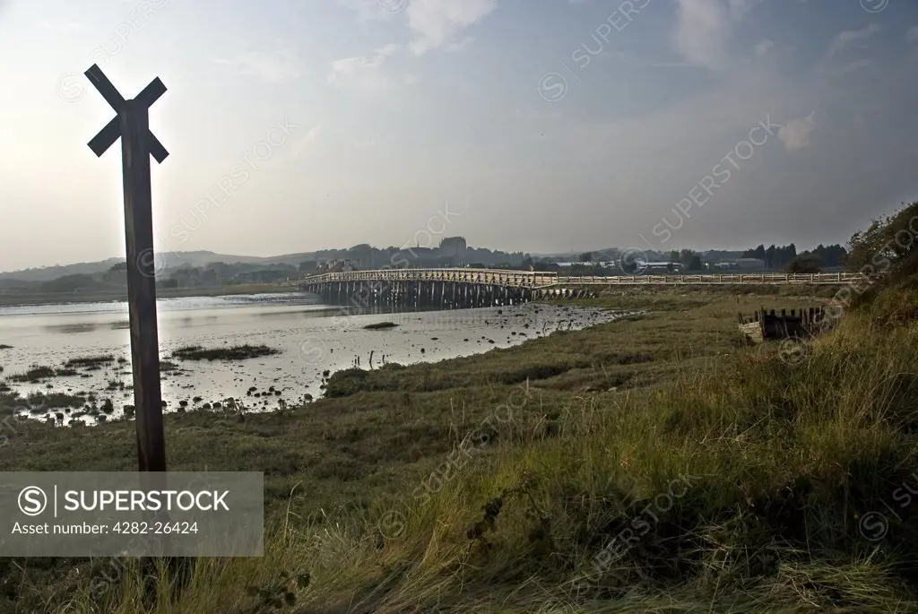 England, West Sussex, Shoreham-by-Sea. A view across the River Adur towards the restored old Shoreham Toll Bridge and Lancing College Chapel.