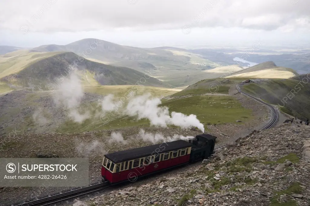 Wales, Gwynedd, Snowdon Mountain Railway. A Snowdon mountain railway steam train pushing a carriage up a mountain on Snowdon. It is over 100 years old and is the only public rack railway in the British Isles.