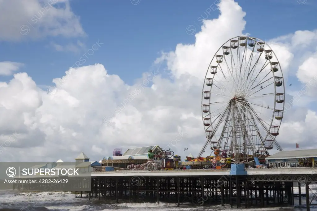 England, Lancashire, Blackpool. Seaside view in summer of a pier with pleasure rides at Blackpool.