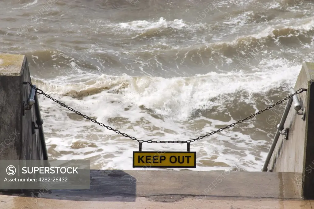 England, Lancashire, Blackpool. Sign and chain preventing access to the beach at high tide at Blackpool.