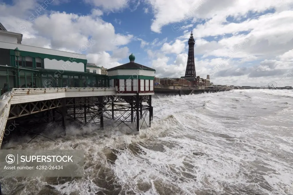 England, Lancashire, Blackpool. Waves lashing the pier and seafront at Blackpool.